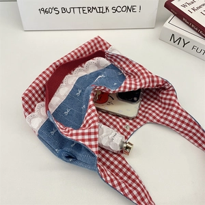 Detail of red gingham and denim bag interior showing phone and cream storage