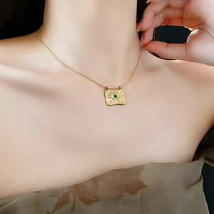 Dettaglio della collana vintage in oro con ciondolo occhio greco verde e zirconi