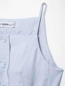 Detail of light blue linen-blend camisole with square neck and decorative buttons