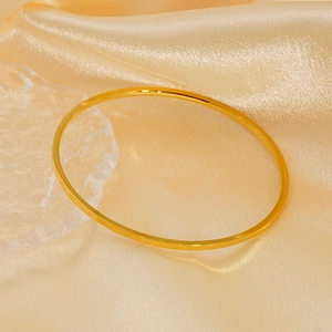 Minimalist 18K gold plated titanium steel bangles set on champagne silk fabric