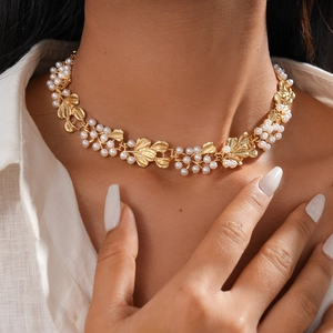 Macro shot of gold leaf texture and white pearl clusters on the vintage choker necklace