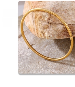 Minimalist 18K PVD gold plated stainless steel hinge bangle on natural stone