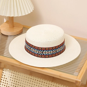 Detail of flat top bohemia straw hat with colorful ethnic ribbon on wooden shelf