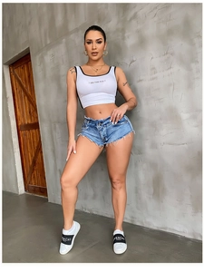 Detail von blauen Denim-Shorts mit ausgefransten Säumen und weißen Plateauschuhen