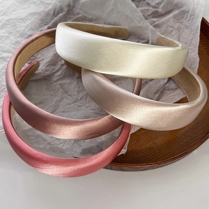 Detail of four thick satin padded headbands in cream, champagne, pink, and grey purple colors