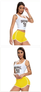 Detail of white cropped tank top with 'Original 91' print and yellow elastic sports shorts