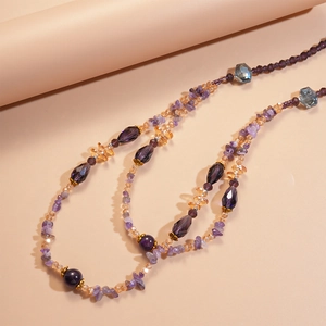 Macro shot of layered amethyst beads and amber crystal accents on a vintage chain