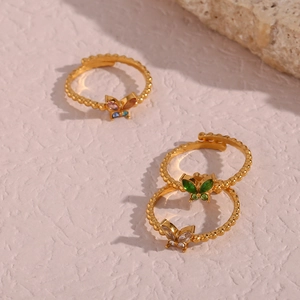 Detaillierte Draufsicht auf drei goldene verstellbare Ringe mit bunten Schmetterlingen