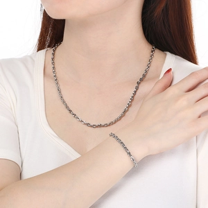 Detailed view of stainless steel interlocking link necklace and bracelet set on model