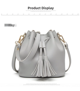 Detail of grey PU leather bucket bag with tassel drawstring and gold-tone hardware