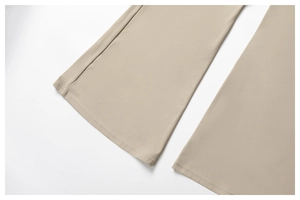 Détail du pantalon de yoga évasé kaki montrant des coutures précises et un tissu lisse