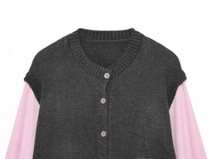 Detail der Strickjacke mit lila Knöpfen und rosa langärmeliger Unterlage aus Strickstoff