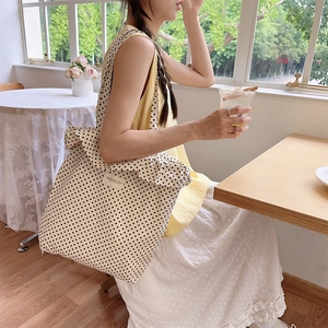 Nahaufnahme einer Canvas-Tragetasche mit Polka Dots und Rüschen im sonnigen Café