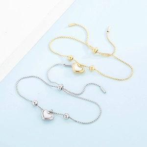 Detailansicht verstellbarer Herz-Armbänder in Gold und Silber mit weißem Muscheleinleger
