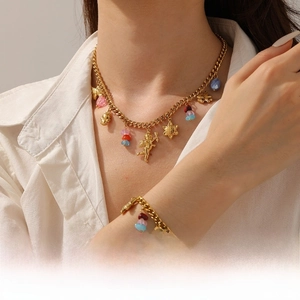 Détail de la chaîne cubaine dorée avec pendentifs Cupidon sur le cou et le poignet