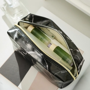 Top view of large capacity black marble pattern makeup bag with gold zipper and beige lining