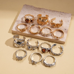 14-piece vintage set of textured gold and silver rings with resin stones on stone base