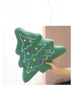 Close-up of green plush Christmas tree pillow with colorful embroidered wave details