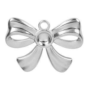 Macro detail of a silver bow pendant made of polished stainless steel for DIY jewelry