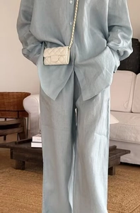 Detail of light blue linen-style two-piece set featuring a loose shirt and trousers