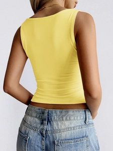 Back view of a tight yellow square-neck tank top paired with light blue jeans