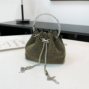 Détail d'un mini sac seau noir avec strass irisés et poignée en anneau métallique