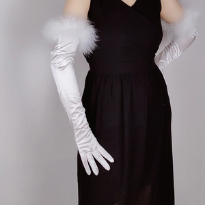 Close-up of elegant long white satin gloves with feather trim on model arms
