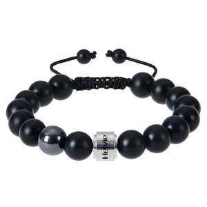 Detail of matte black stone beads and custom engraved metal cylinder on men's bracelet