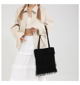 Dettaglio della borsa tote in tulle nero con volant plissettati e tracolla sottile
