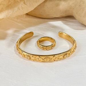Golden celestial jewelry set with sun moon star patterns on cuff bracelet and ring