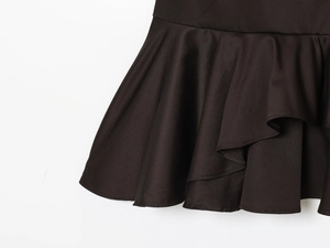 Detailed view of layered ruffle hemline on a black bohemian fashion vacation dress