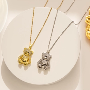Detailed view of gold and silver teddy bear pendants encrusted with sparkling crystals