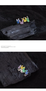 Detail of silver bunny rings with colorful enamel heads on dark textured background