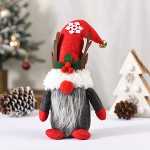 Christmas gnome doll with reindeer antlers and red snowflake hat in holiday scene