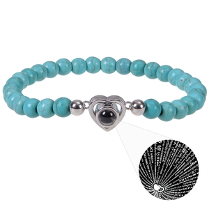 Detail of blue turquoise bead bracelet with silver heart projector stone showing I Love You