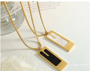 Detail of minimalist rectangular pendants with black and pearlescent inlays on box chains