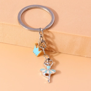 Detail of silver ballet dancer and gold crown charms on a metal keychain strap