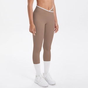 Détail d'un legging de yoga taille haute avec taille en V croisée et liserés blancs