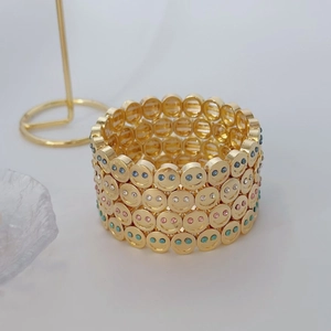 Set of four gold-plated smiley face bead bracelets with colorful rhinestones for women