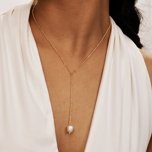 Elegant gold Y-shaped stainless steel necklace with a lustrous white pearl drop on model