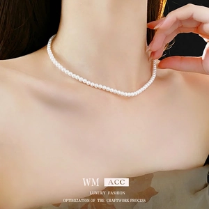 Collier ras de cou élégant en perles blanches pour femme porté par un mannequin
