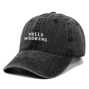 Detail of white HELLO WEEKEND embroidery on washed black cotton baseball cap