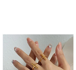 Détail d'une bague ouverte dorée avec barre transversale portée au doigt