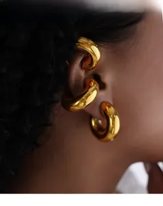 Close-up of polished gold-plated geometric ear cuff on model with a glossy mirror finish