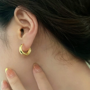 Minimalist thick gold hoop earrings for women featuring a polished metallic finish