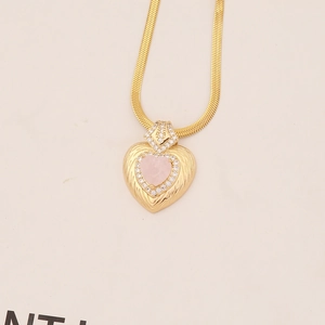 Golden heart necklace with pink stone and feathered texture on gold snake chain