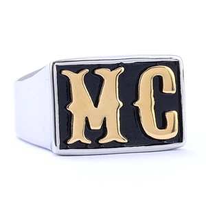 Macro shot of rectangular black signet ring featuring a golden MC logo on stainless steel