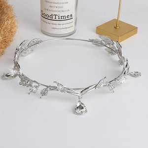 Silver crystal bridal crown with leaf design and pear-shaped rhinestones on a white display