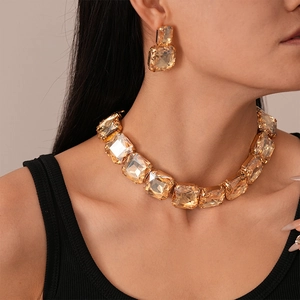 Macro view of gold-tone necklace and earring set with square-cut champagne crystals