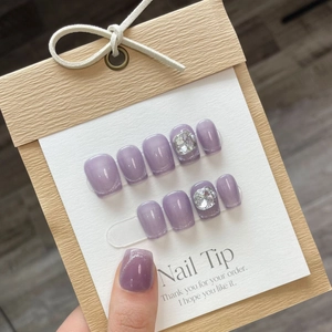 Handmade lavender cat-eye press-on nails set with sparkling rhinestones on display card